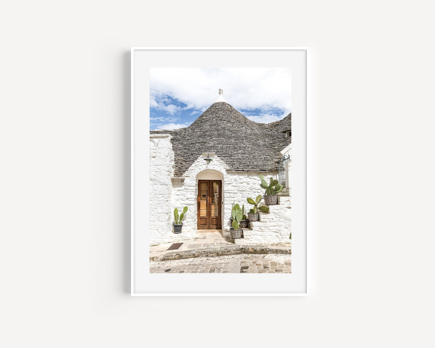 Vertical photo of trullo house in Alberobello, Italy with potted cactus and textured white stone walls – Mediterranean architectural print