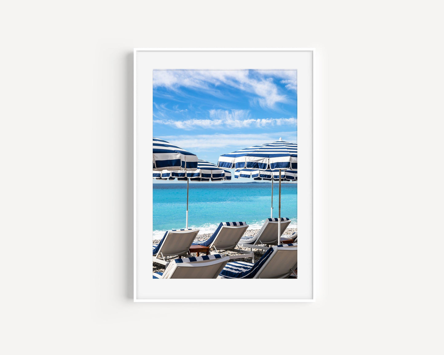 Striped blue and white umbrellas at Ruhl Plage Beach Club in Nice, France.