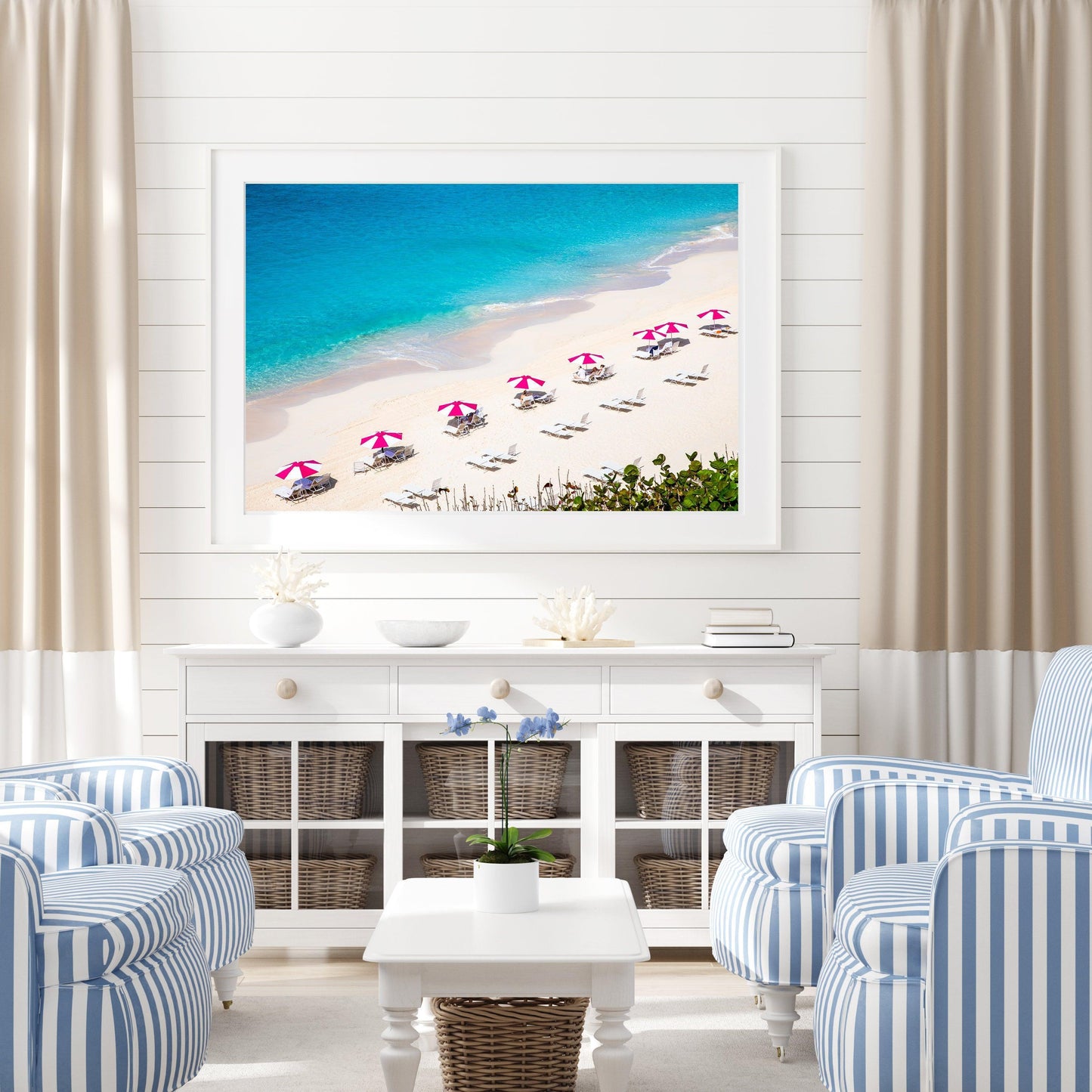 Bright pink beach umbrellas on Bermuda’s sandy shore with turquoise waters in the background.