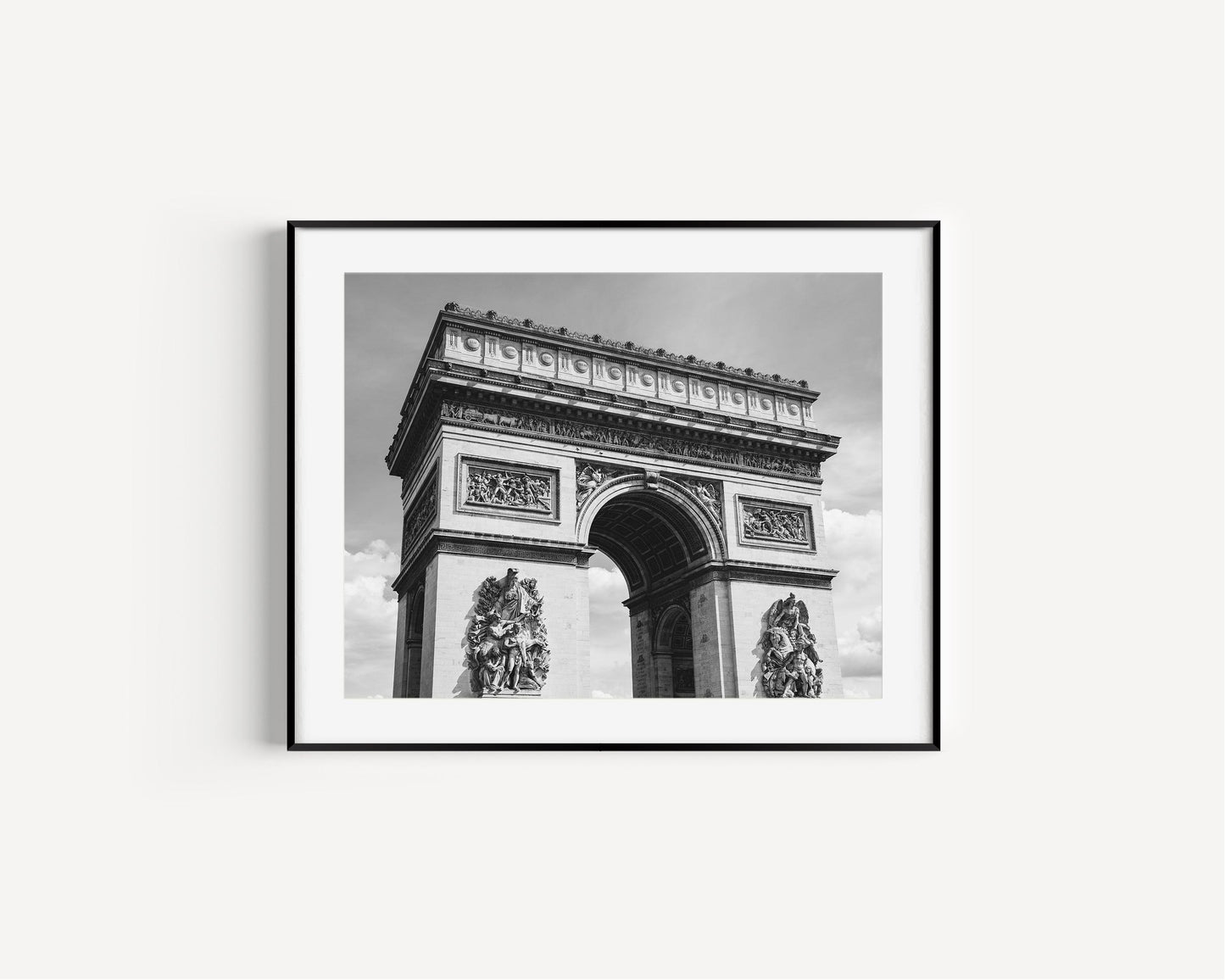 Black and white photograph of the Arc de Triomphe in Paris, taken from the Champs Elysées with strong architectural lines and soft contrast.