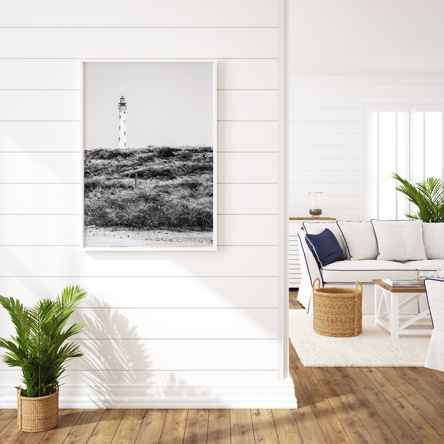 Black and white photo of the Aruba lighthouse standing tall against a bright sky, ideal for beach house decor or coastal wall art.