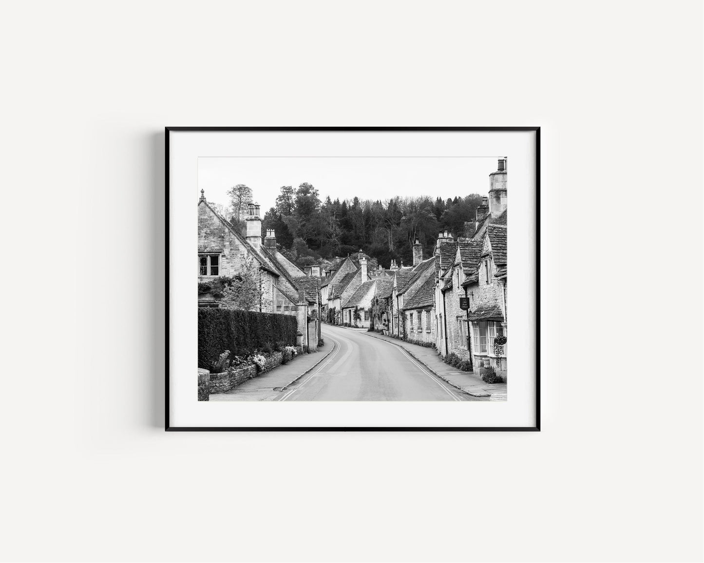 Black and white photo of Castle Combe village in the Cotswolds with old stone cottages and winding road – English countryside wall art.