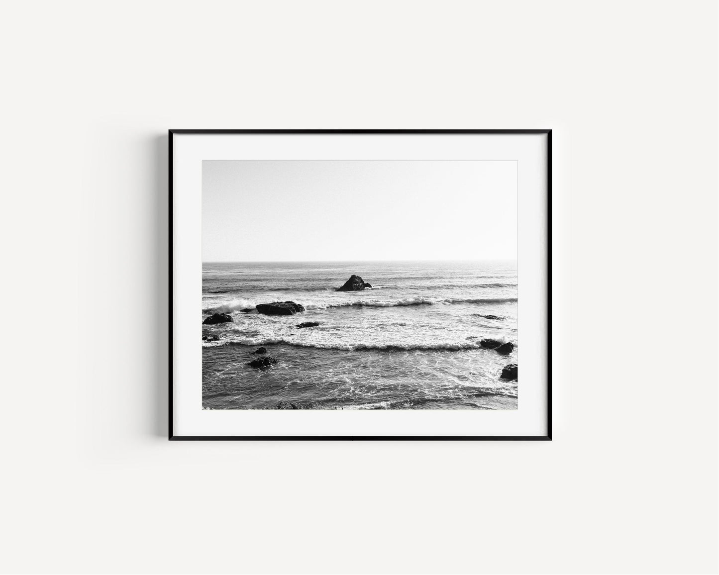 Black and white photo of ocean waves and rock along the California coast – minimalist horizontal wall art