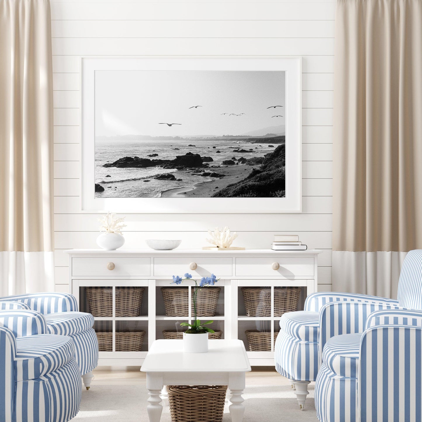 Black and white photo of birds flying over California coast with ocean waves and rocky shoreline