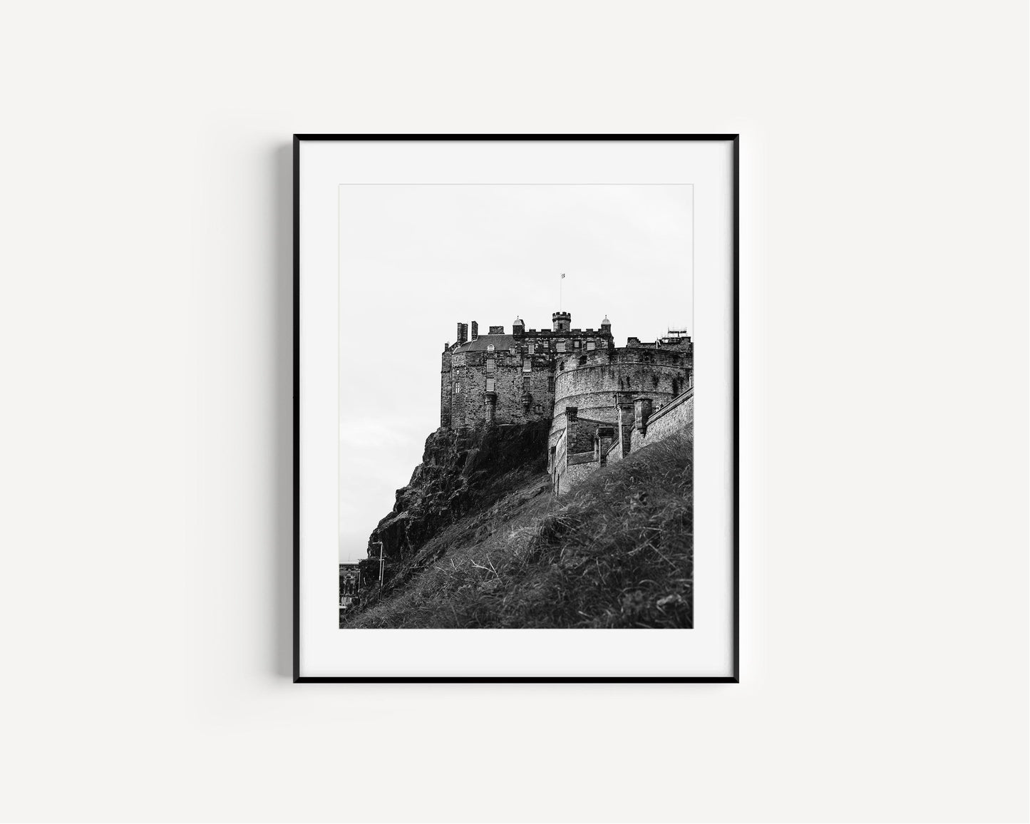 Vertical black and white photo of Edinburgh Castle in Scotland with hill and cloudy sky – historic architectural wall art