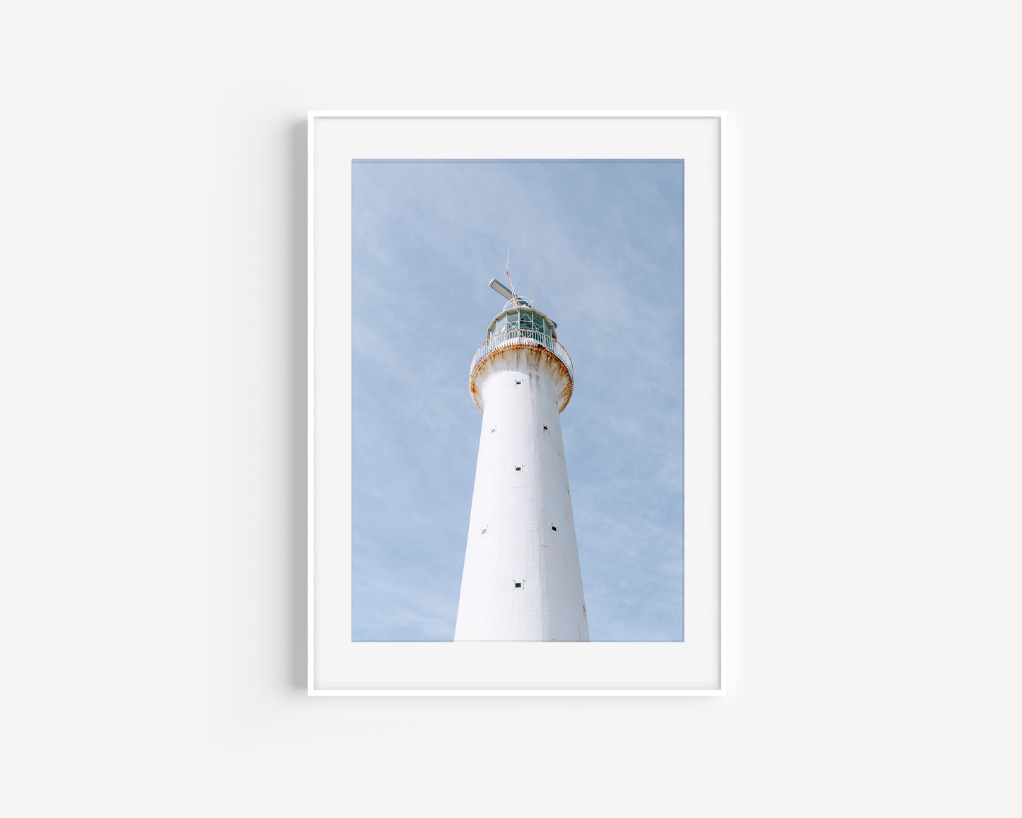 Vertical photo of Gibbs Hill Lighthouse in Bermuda against a soft blue sky