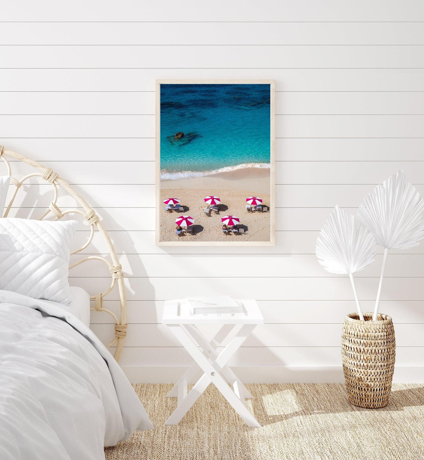 Aerial view of five pink beach umbrellas on a Bermuda shoreline with turquoise water