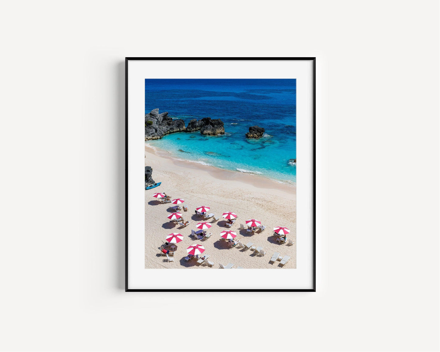 Pink and white beach umbrellas by the ocean taken in Bermuda