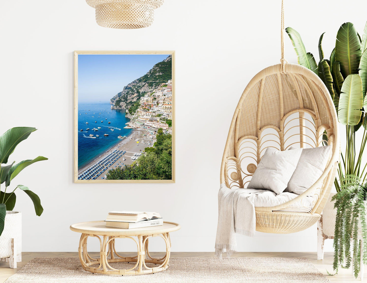 Colorful buildings stacked along the cliffs of Positano rise above a beach filled with striped umbrellas and sunbathers on the Amalfi Coast in Italy.