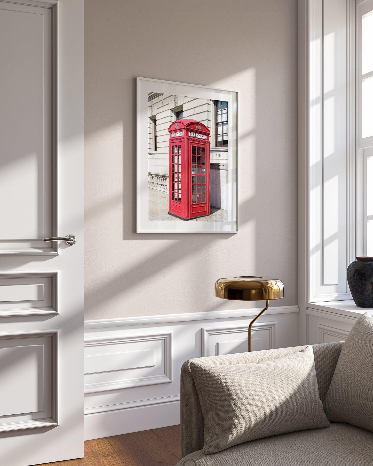 A classic red telephone booth stands out in vivid color against a black and white London street scene. A bold and graphic British landmark print for home or office decor.