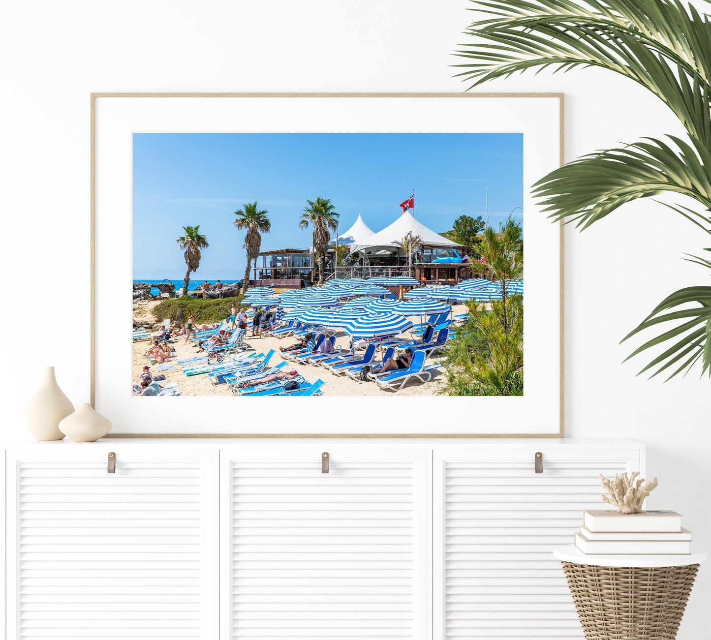 Blue beach umbrellas along the shoreline of Tobacco Bay, Bermuda, with turquoise waters in the background.