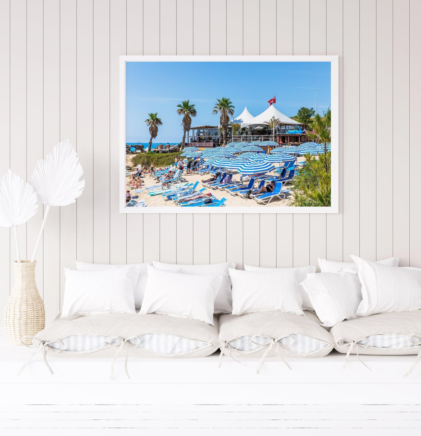 Blue beach umbrellas along the shoreline of Tobacco Bay, Bermuda, with turquoise waters in the background.