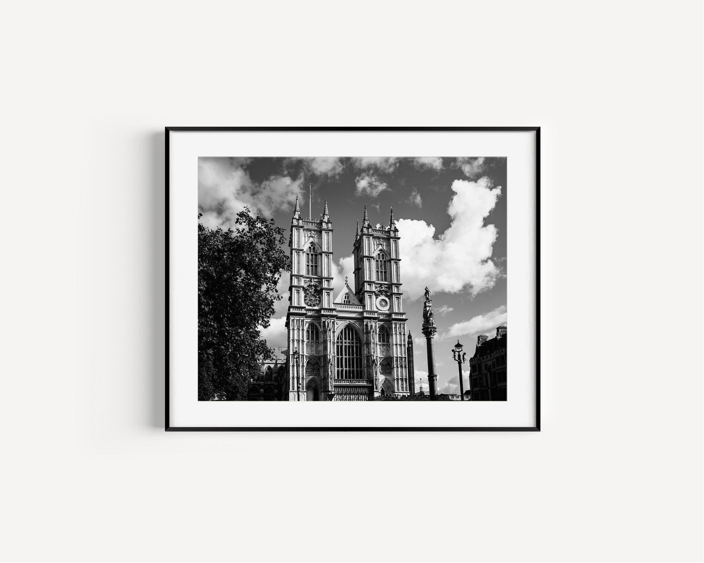 Black and white photograph of Westminster Abbey in London featuring detailed gothic architecture under a cloudy sky.