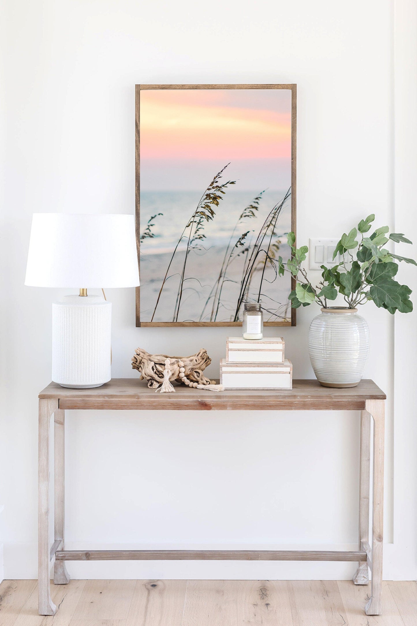 Sea oats on a sandy beach at sunset with soft pastel sky and ocean in the background