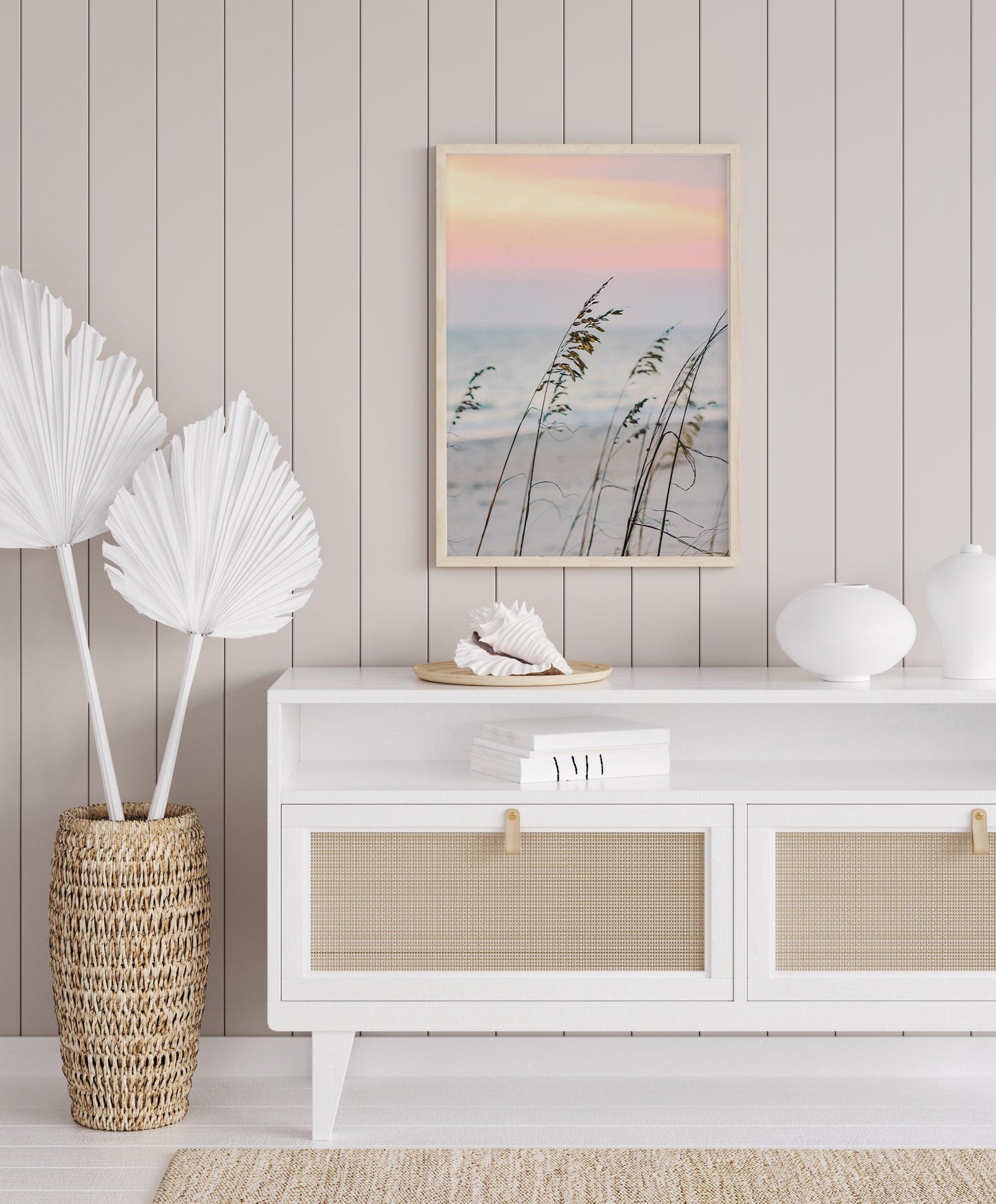 Sea oats on a sandy beach at sunset with soft pastel sky and ocean in the background