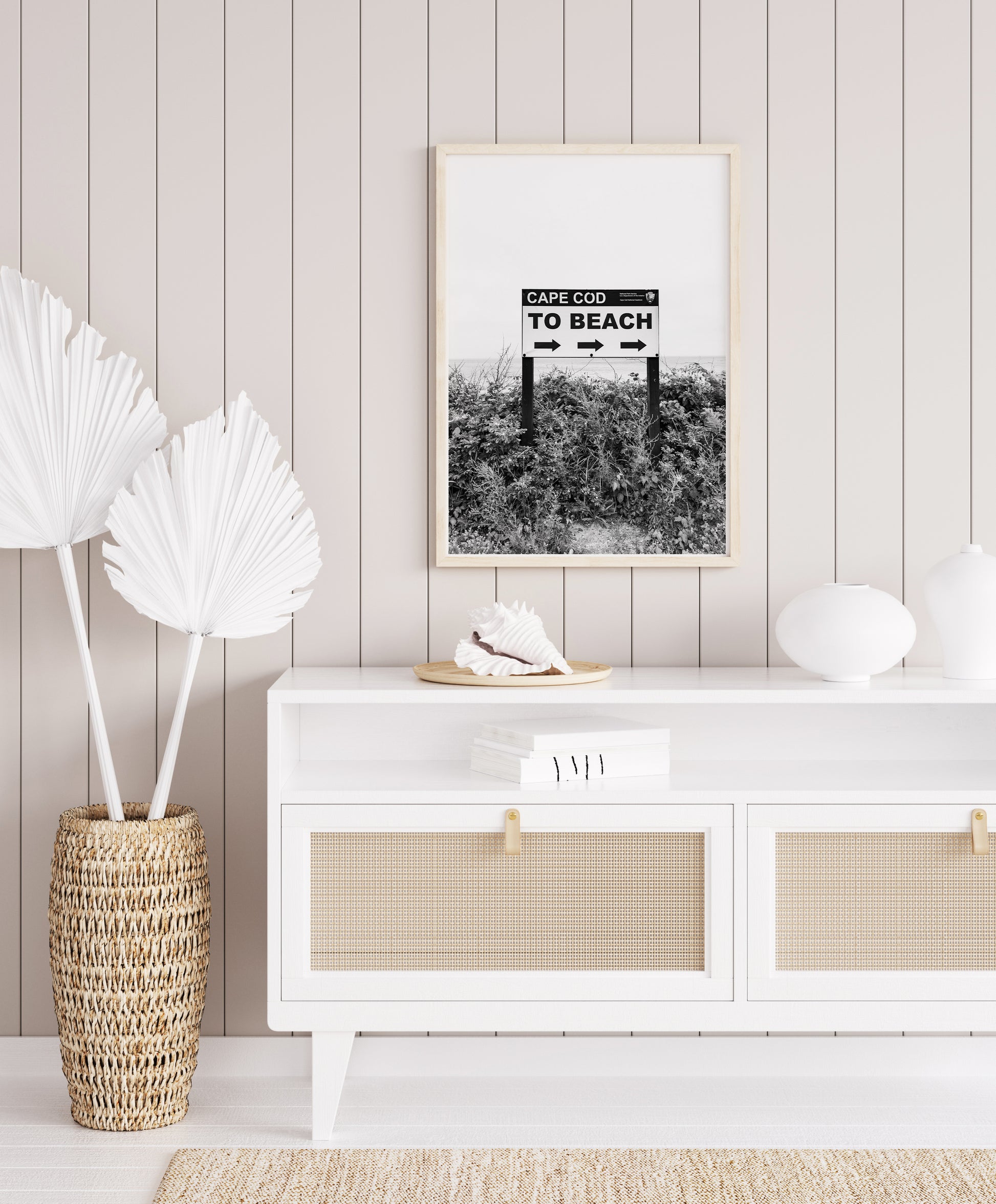 Black and white photography print of a vintage-style sign reading 'Cape Cod Beach This Way' with an arrow, set against a clear sky.