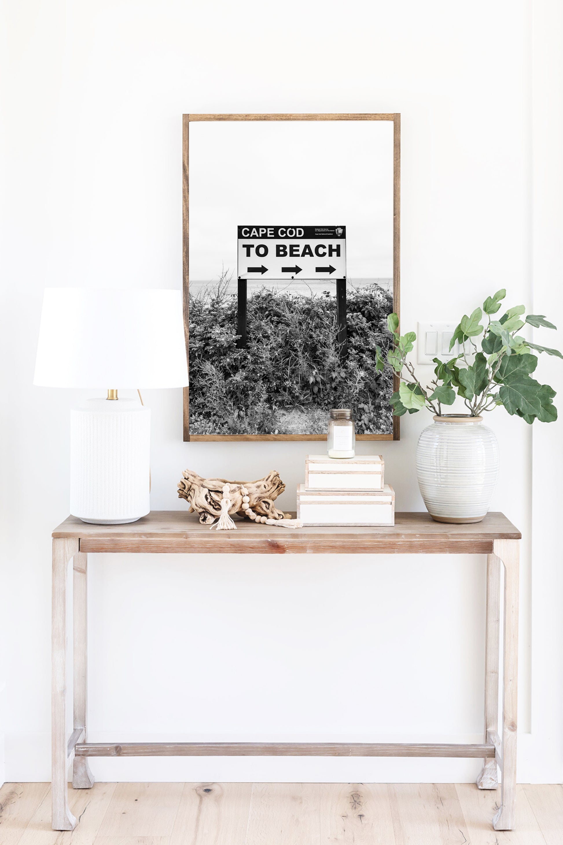 Black and white photography print of a vintage-style sign reading 'Cape Cod Beach This Way' with an arrow, set against a clear sky.
