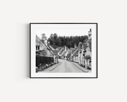 Black and white photo of Castle Combe village in the Cotswolds with old stone cottages and winding road – English countryside wall art.