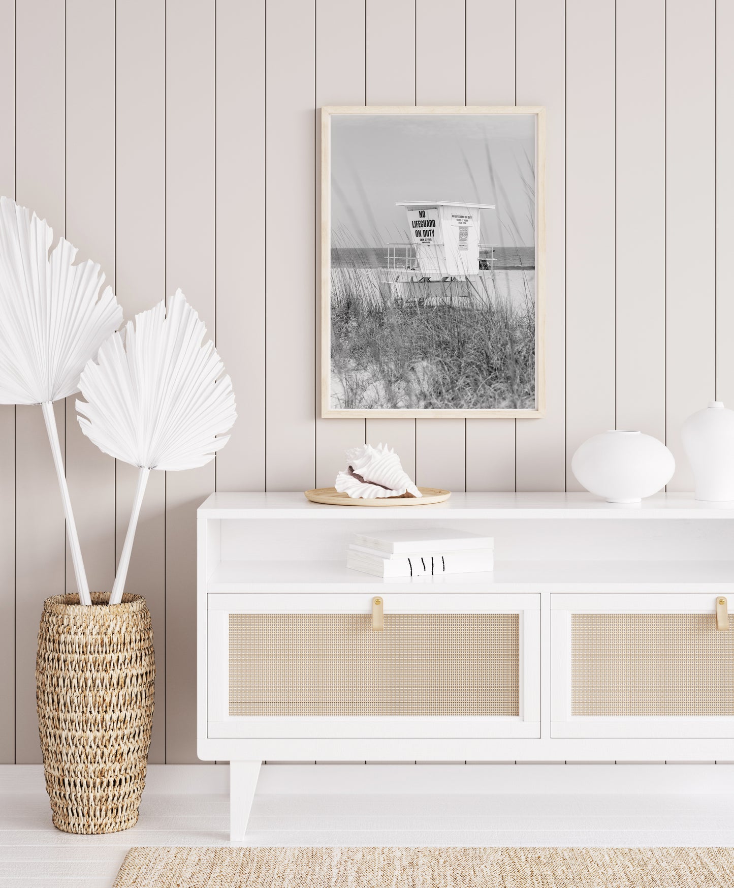 Black and white photograph of a lifeguard station on a quiet beach with sea grass in the foreground