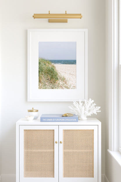 Neutral-toned beach photography of sand dunes and beach grass under a pale sky, evoking a coastal New England feel with a Nantucket aesthetic