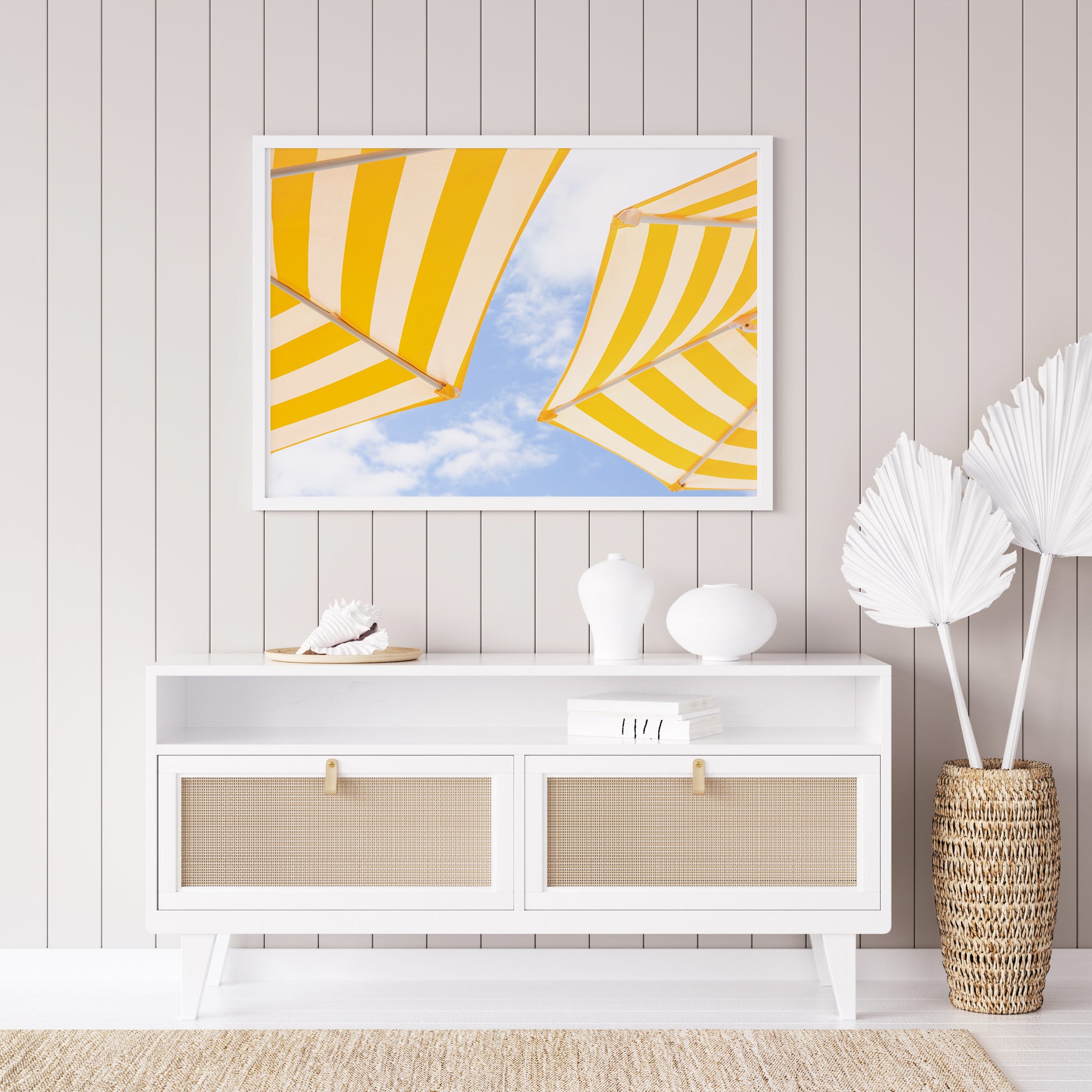 Yellow and white striped beach umbrellas set against a bright blue sky with scattered clouds; minimalist beach photography evoking a sunny Amalfi Coast vibe.

