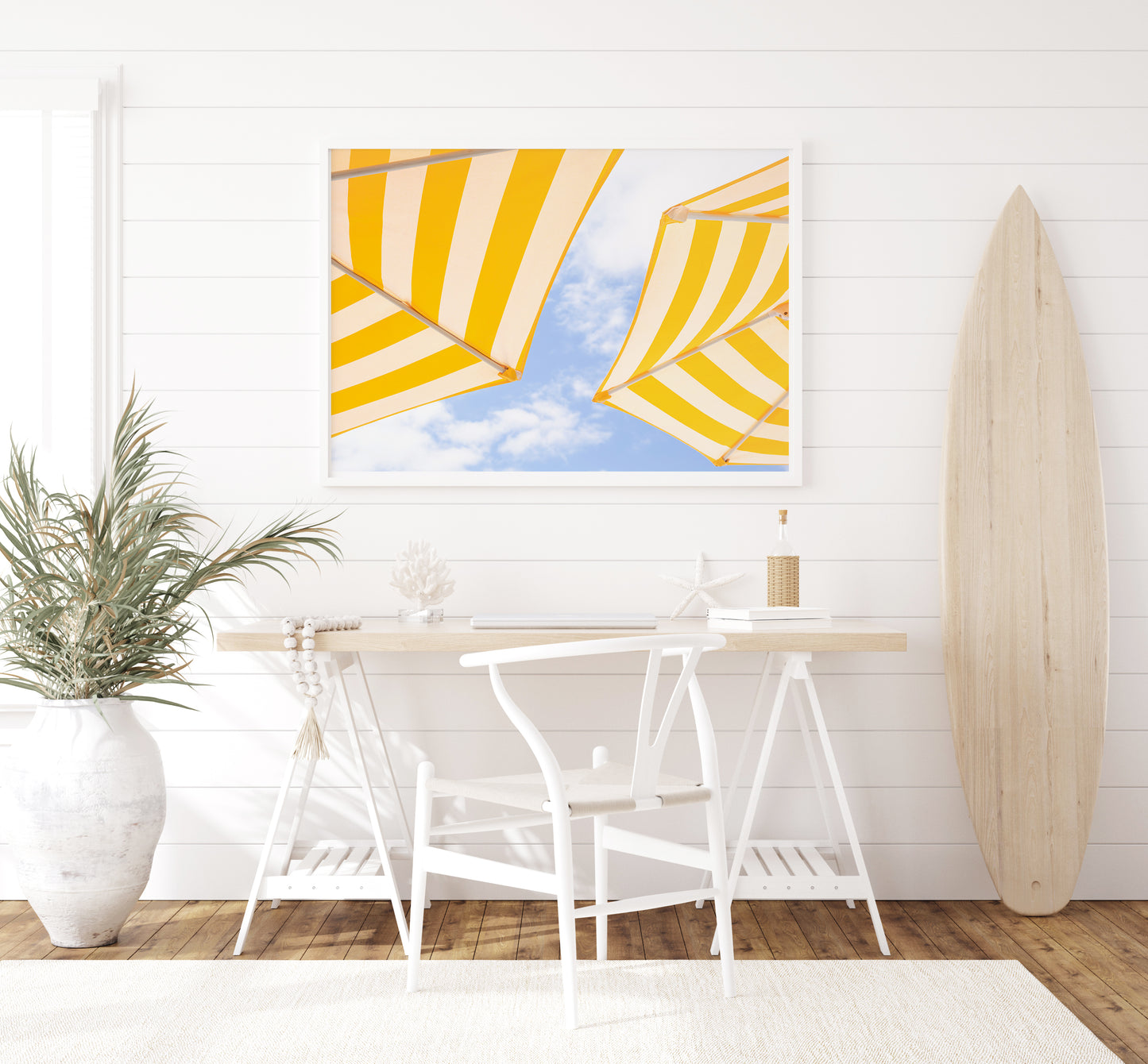 Yellow and white striped beach umbrellas set against a bright blue sky with scattered clouds; minimalist beach photography evoking a sunny Amalfi Coast vibe.